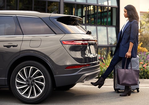 A woman with her hands full uses her foot to activate the hands-free liftgate. | John Vance Auto Group in Guthrie OK