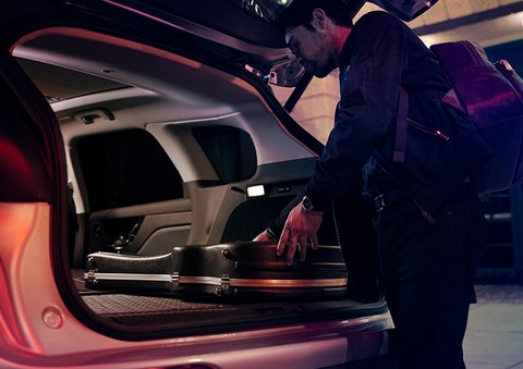 A man is shown loading cargo into the rear of a 2023 Lincoln Corsair® SUV with the second-row seats folded flat. | John Vance Auto Group in Guthrie OK