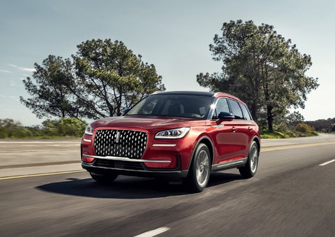 A 2023 Lincoln Corsair® SUV is shown being driven on a country road. | John Vance Auto Group in Guthrie OK