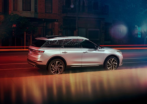A 2023 Lincoln Corsair® SUV is shown parked in the city at night. | John Vance Auto Group in Guthrie OK